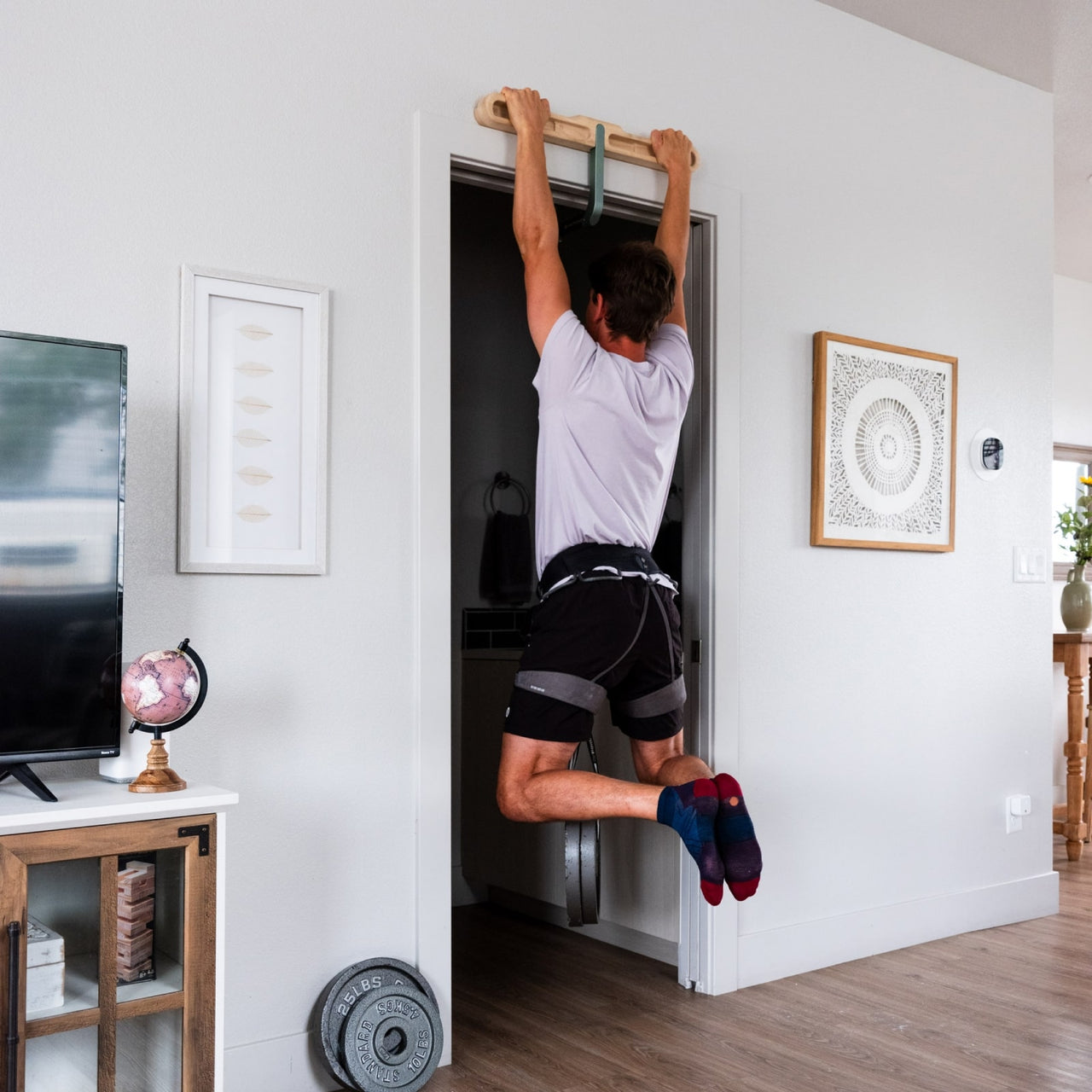 Person doing pull up on DoorMount Pro with weights