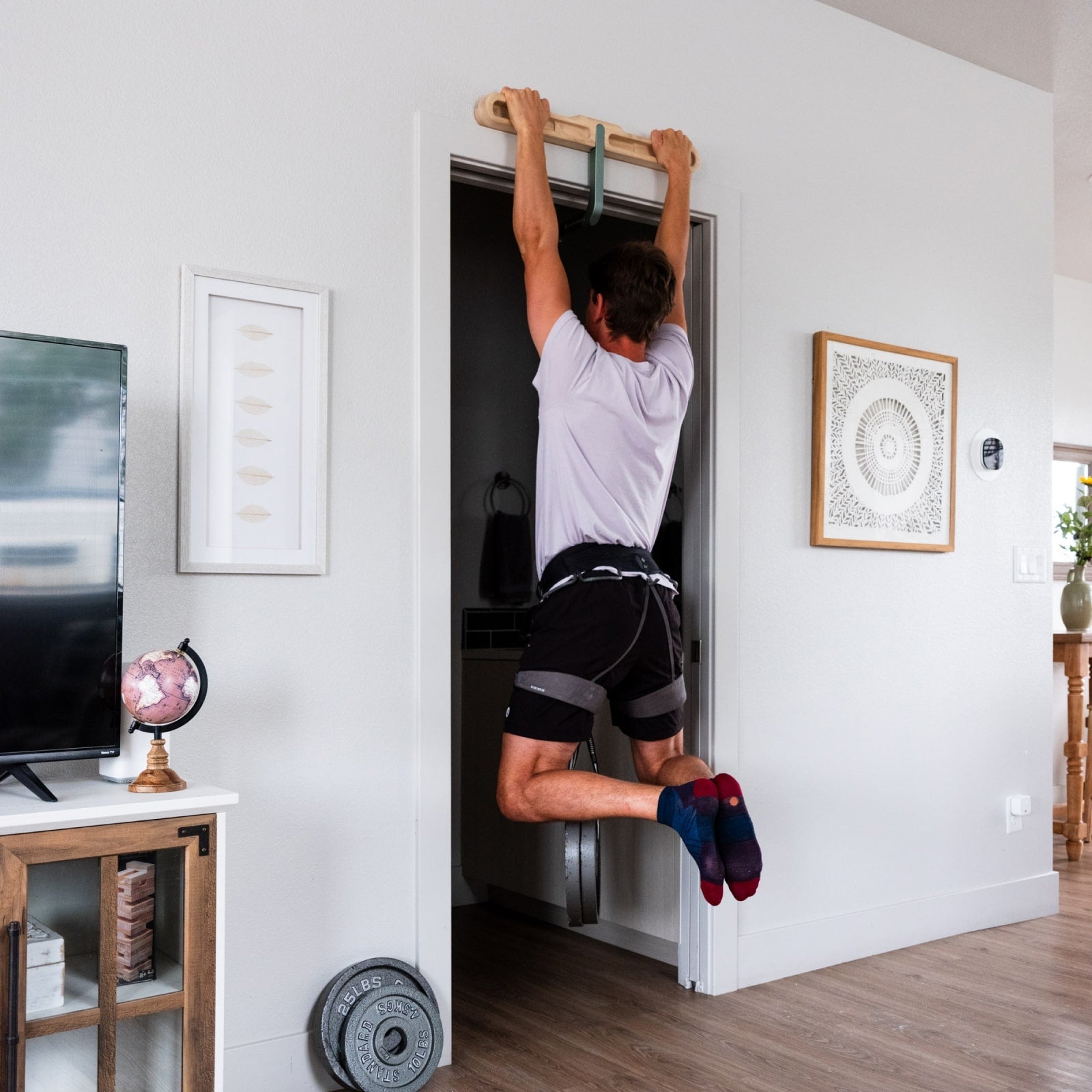 Person doing pull up on DoorMount Pro with weights
