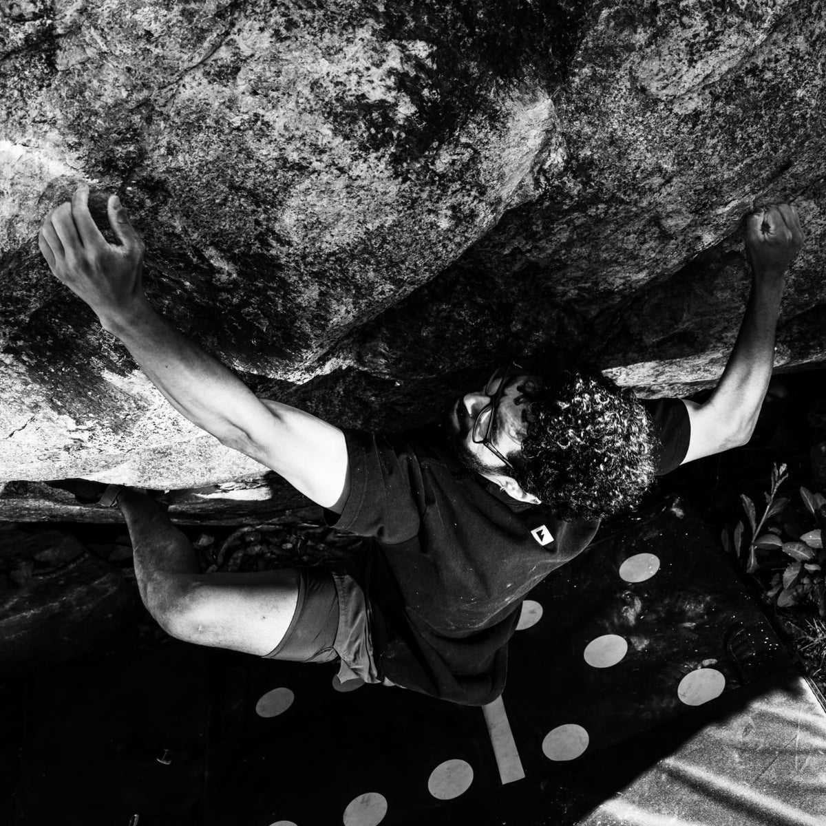 Pedro climbing while wearing the black logo tee